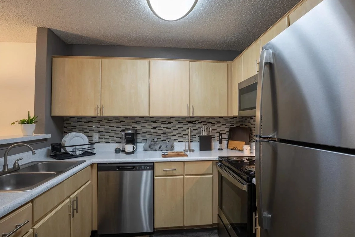 Modern kitchen with stainless steel appliances at Village Green of Bear Creek in Euless, Texas