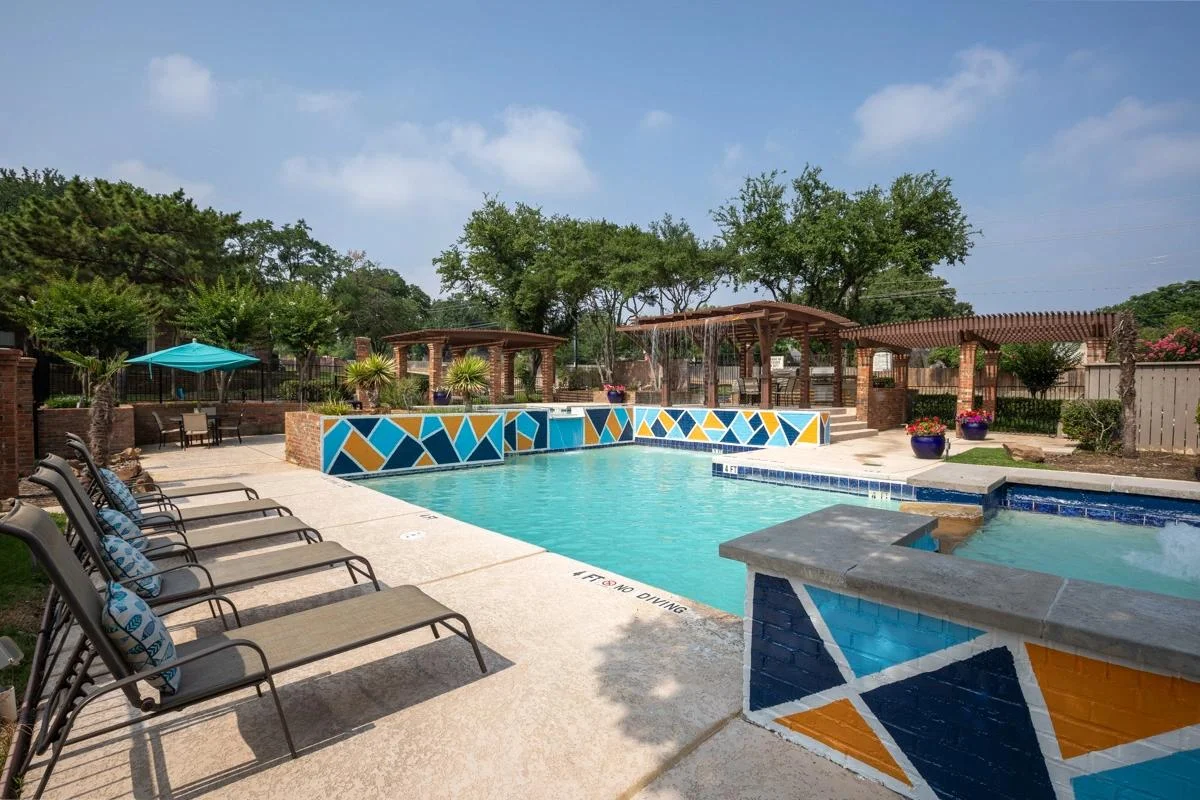 Resort-style swimming pool and pergola sun deck at Village Green of Bear Creek in Euless, Texas