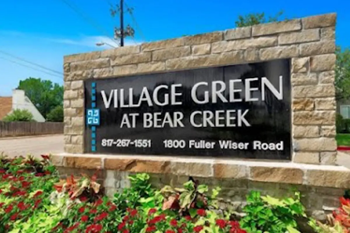 Main monument entrance and community signage at Village Green of Bear Creek in Euless, Texas