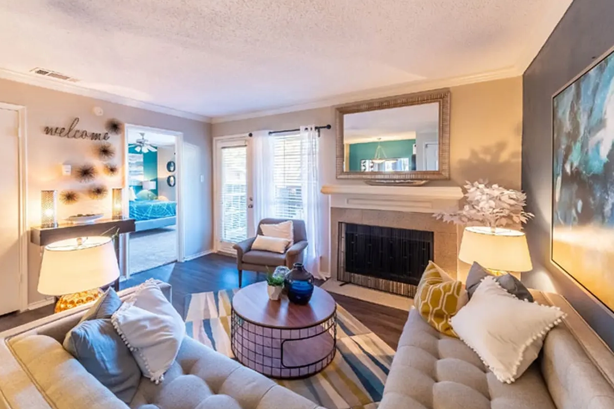 Contemporary living room with fireplace inside an apartment at Village Green of Bear Creek in Euless, Texas
