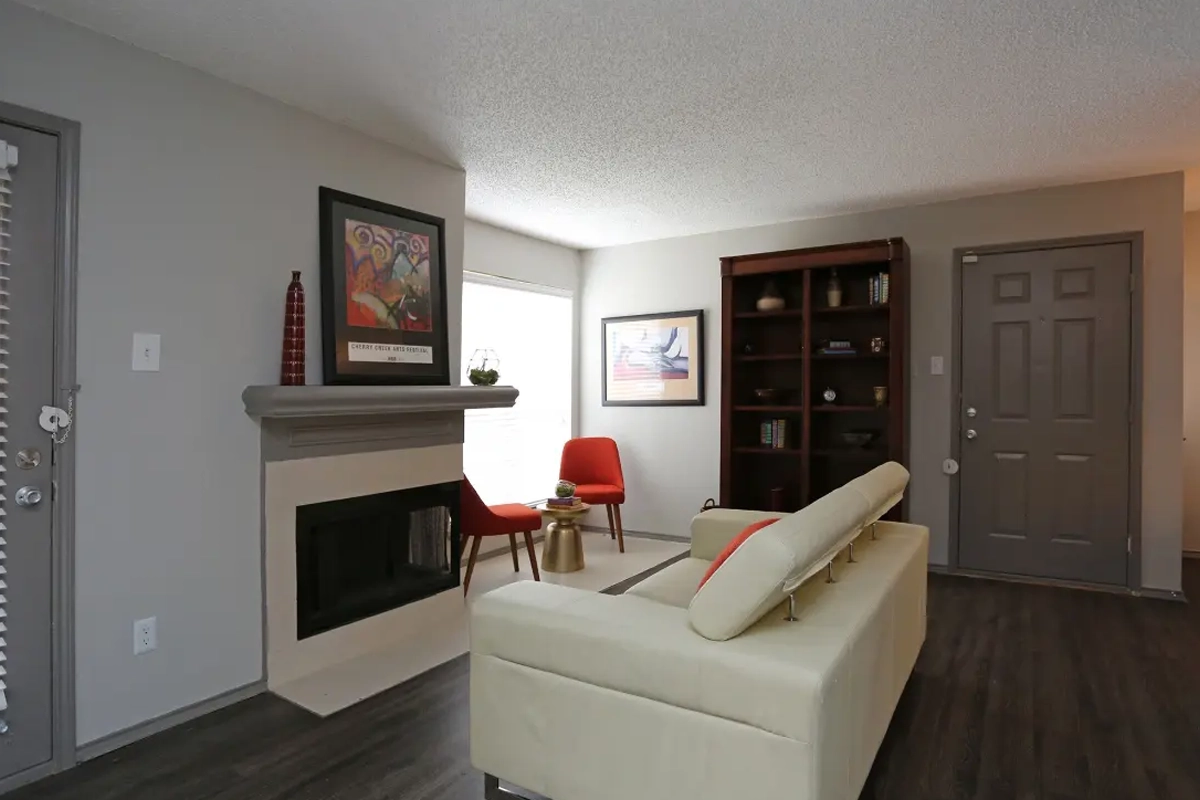 Living room with cozy fireplace inside an apartment at Village Green of Bear Creek in Euless, Texas