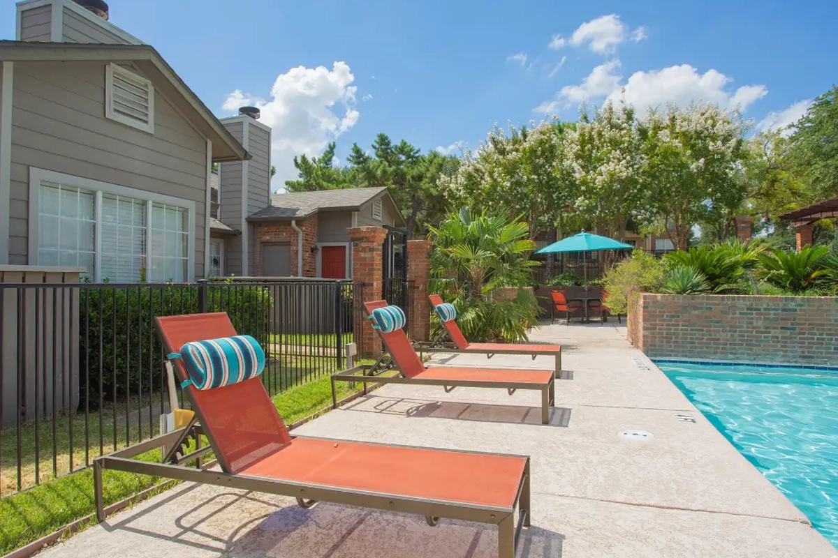 Resort-style swimming pool and sundeck at Village Green of Bear Creek in Euless, Texas