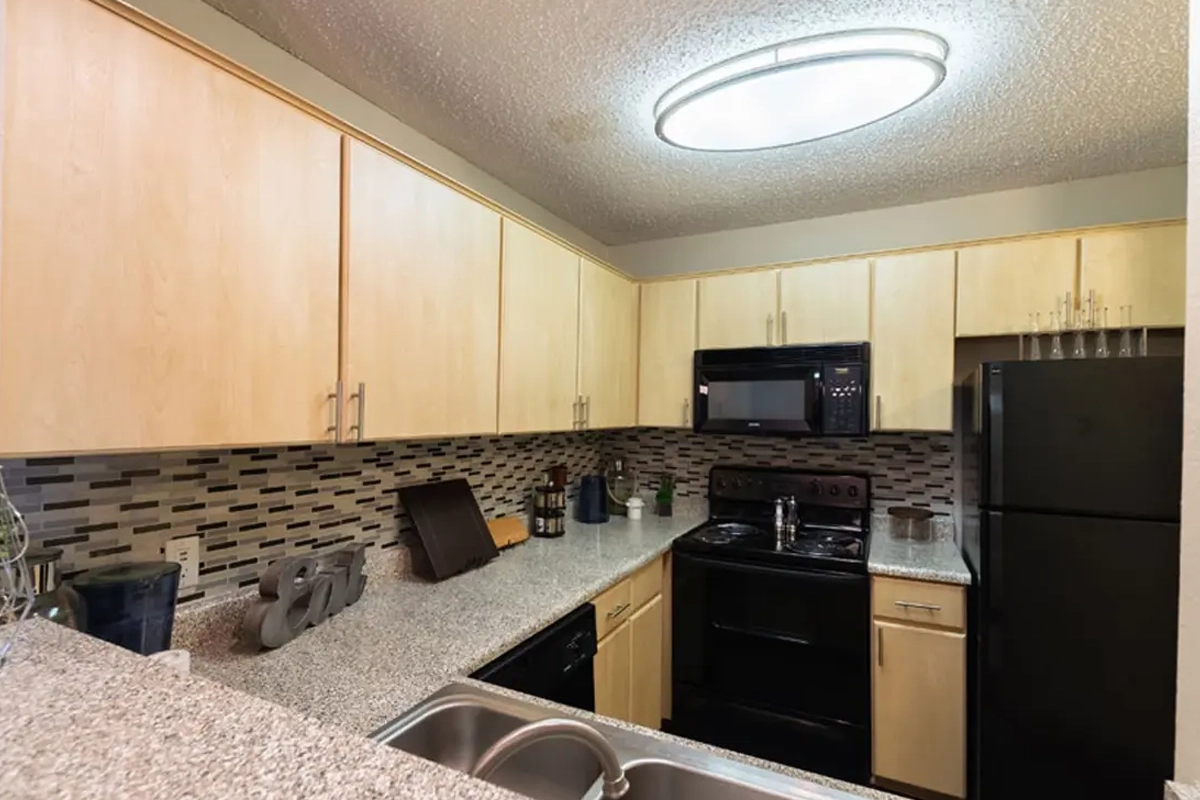 Fully equipped modern kitchen inside an apartment at Village Green of Bear Creek in Euless, Texas