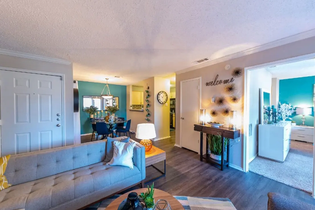 Open-concept living area and foyer entry inside an apartment at Village Green of Bear Creek in Euless, Texas